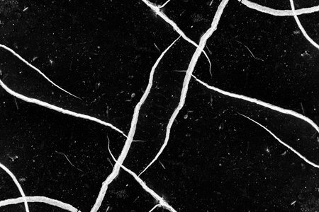 Scattered white crack texture on dusty black background