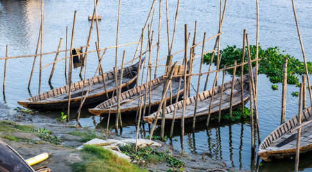 A row of parked wooden passenger boats on the river in the rural villageの写真素材