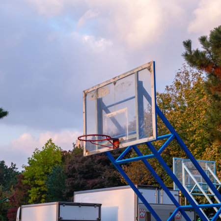 Basketball hoop in a basketball court at sunset on a cloudy day