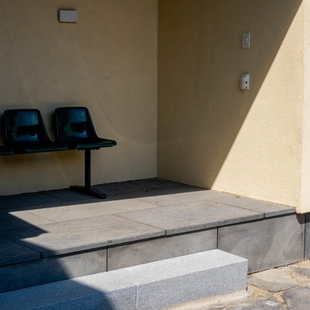 Empty bench in front of the entrance to the building. Nobody insideの写真素材