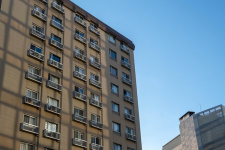 Residential building with balconies and windows against the blue sky.の写真素材