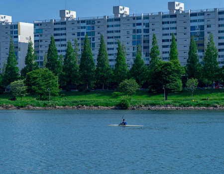 A man in a kayak floats on the river in the city