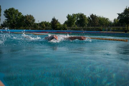 Swimmer standing next to a pool on a sunny morning