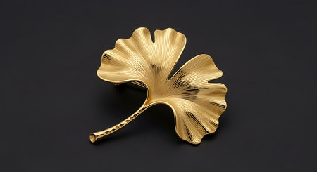 Elegant ginkgo leaf brooch. Gold metal accessory. Precious ornament.の素材