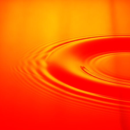 Circular ripple effect on orange color water surface backgrounds. Liquid wave motion is captured in this backdrop. Dynamic and visually appealing design element.の素材