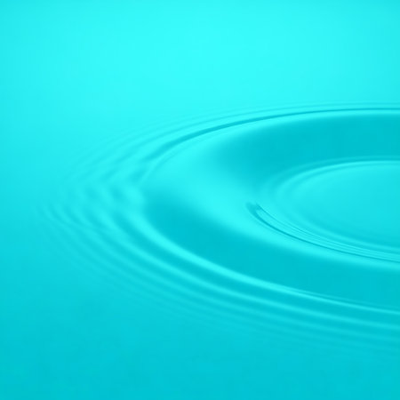Aqua blue water surface with ripples spreading out from single drop. Water ripple textured backdrop conveys calm and soothing. Fluid dynamic background for designs conveys serenityの素材