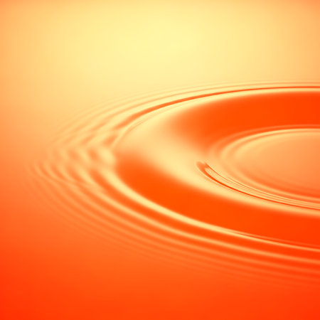 Vibrant orange liquid ripples creating circular pattern on smooth surface. Water ripple effect and vibrant color makes interesting visual texture. Liquid dynamic movement is calming and hypnotic. Abstract waves background.の素材