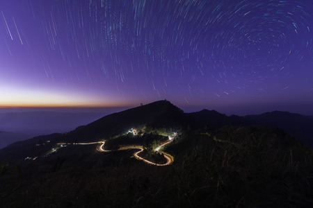 Beautiful scenery during the twilight after the sunset and star trail movement of top view at Doi Pha Tang, Chiang Rai in Thailand.の写真素材