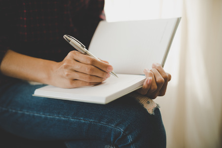 Woman hand writing on notebook. Education concept