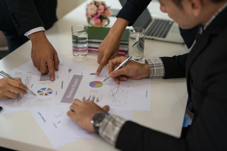 Group of businesspeople at meeting discussing ideas while looking at the graphs and chartsの写真素材
