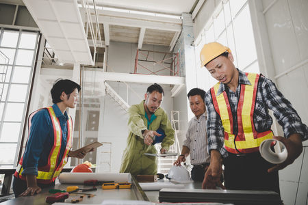 A group of male and female engineers are meeting to talk about plans for the construction of the building. teamwork conceptの写真素材