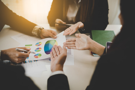 A group of business men and women are meeting together to see graphs about business marketing sales target. teamwork business meeting conceptの写真素材