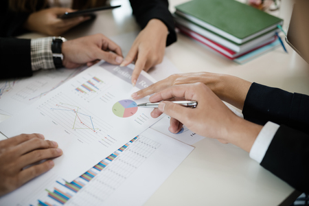 A group of business men and women are meeting see report on businessの写真素材