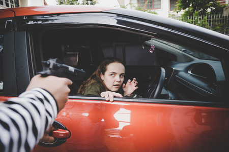 Thieves use a gun to force a woman to submit your property is worth.の写真素材