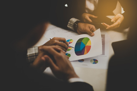 A group of business men and women are meeting together to see graphs about business marketing sales target. teamwork business meeting conceptの写真素材