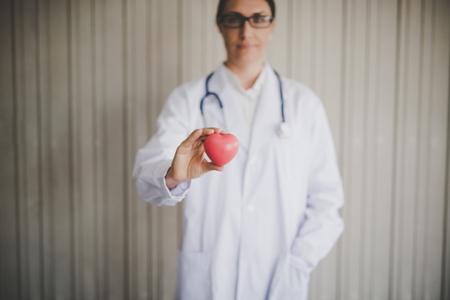 Woman doctor holding a red heartの写真素材