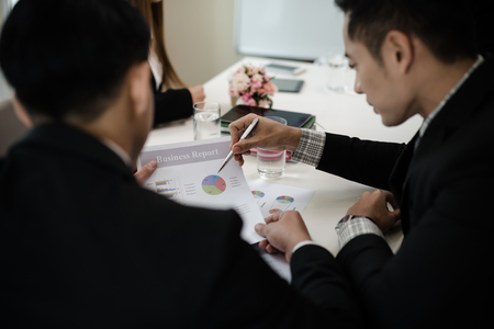 A group of business men and women are meeting see report on businessの写真素材