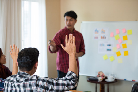 Hand of young Asian men wearing casual plaid shirt is asking for feedback from he colleagues at the...