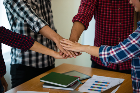 Asian business man and business woman dressed in a striped shirt Scottish are joining hands at home office. Startup Concept.Team work business ideas concept.の写真素材