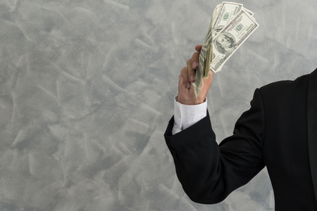 Hand of a businessman holding cash are successful in business, with many banknote dollars money. business success conceptの写真素材