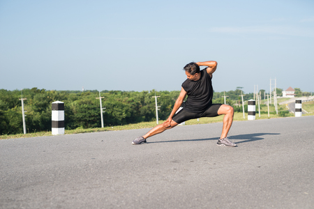 Male runners are stretching the leg muscles to prepare for a run in the morning. The concept of health and fitnessの写真素材