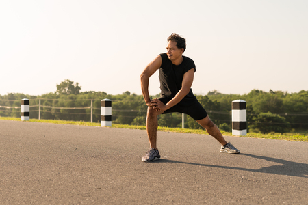 Male runners are stretching the leg muscles to prepare for a run in the morning. The concept of health and fitnessの写真素材