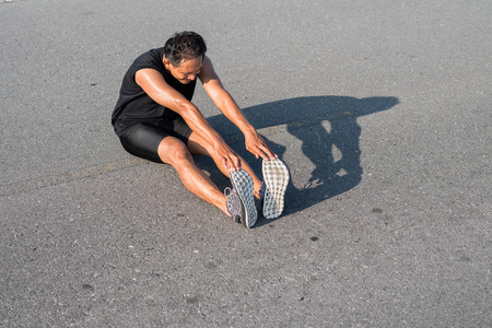 Male runners are stretching the leg muscles to prepare for a run in the morning. The concept of health and fitnessの写真素材