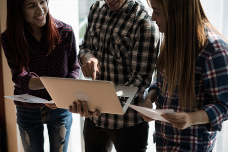 A group of people working man and woman in the plaid shirt Use your laptop to work and talk. teamwork businessの写真素材