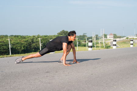 Male runners are stretching the leg muscles to prepare for a run in the morning. The concept of health and fitnessの写真素材
