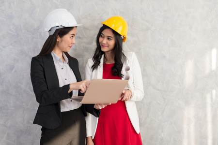 Business girl and engineer with Asian people work with laptop are talking about a new project within the business office.の写真素材