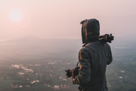 Man traveler photographer and camera taking photo on mountains In the morning the sun rises. Travel Lifestyle hobby conceptの写真素材