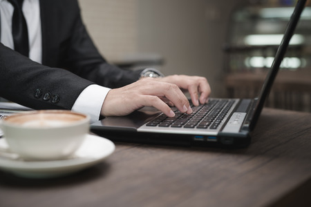 Young Asian businessman working with a laptop in a coffee shop.の写真素材