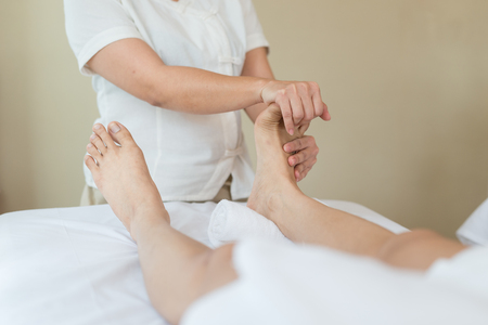 Asian girl relaxing having feet massage in a spa salon, close up viewの写真素材