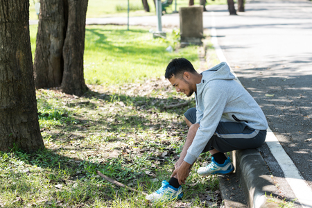 Asia young man runner has inflammation and swelling cause a pain the sore ankle, Healthy lifestyle and Men touch knee and feel pain. concept of injuries from exercising.の写真素材