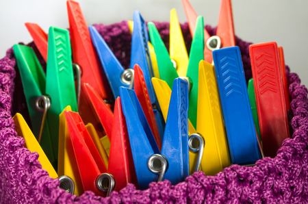 Group of Colorful Clothespins in a Purple Basketの写真素材