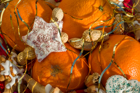 Christmas Still with Oranges Peanuts and Star Decoration Covered with Angel Hair Closeupの写真素材