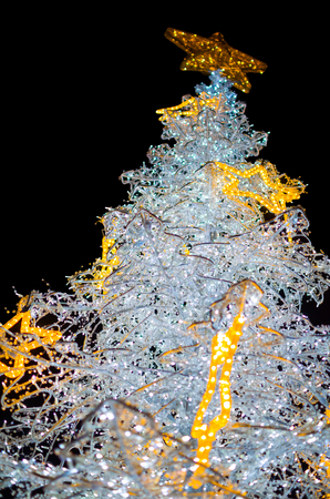 White Christmas Tree with Yellow Stars Decoration Lights Closeup Isolated on Black Backgroundの写真素材