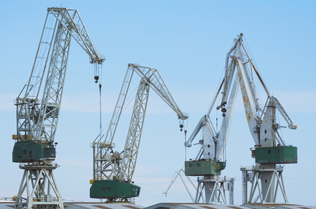 Four Giant Shipyard Cranes Against Blue Skyの写真素材