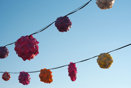 Backlit Twisted Plastic Lanterns Against Clear Blue Skyの写真素材