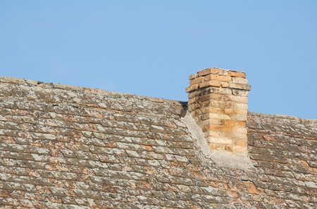 Old Chimney on the Weathered Rooftop and Blue Skyの写真素材