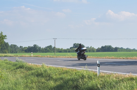 Black Biker Alone on the Road on a Summer Dayの写真素材