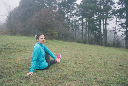 Woman Stretching in the Nature on the Ground before Runningの写真素材