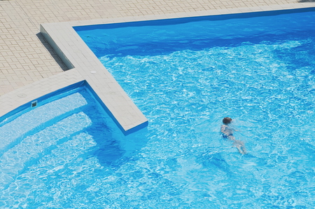 Child in Blue Swimming Pool on a Summer Dayの写真素材