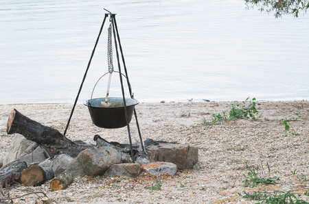 Black Cauldron on Tripod on the River Bankの写真素材