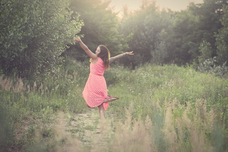 Young Tattooed Woman Dancing on Forest Glade on a Summer Dayの写真素材