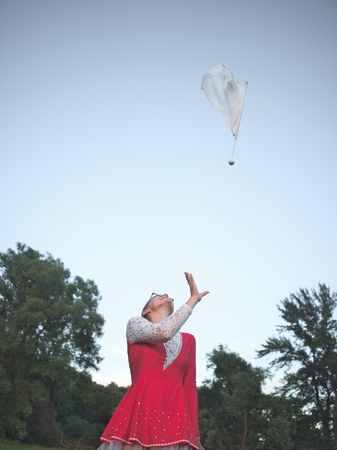 Bespectacled Blonde Teen Majorette Girl with White Flag Outdoors in Red Dressの写真素材