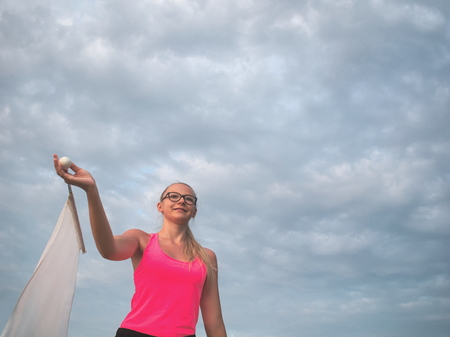 Bespectacled Blonde Teen Majorette Girl with White Flag Outdoorsの写真素材