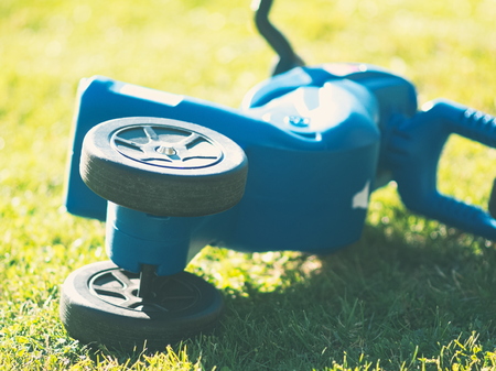 Blue Plastic Motorcycle Toy Closeup on Green Grassの写真素材