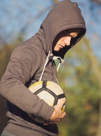 Soccer Player Posing with Football in the Park on a Sunny Autumn Dayの写真素材