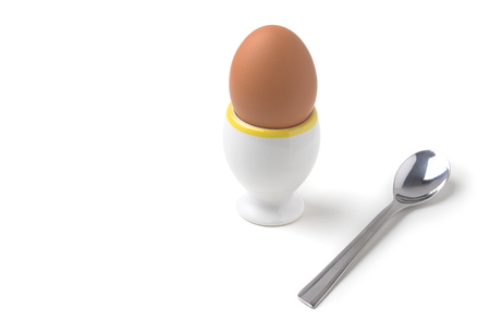 Chicken Egg in Egg Cup with Teaspoon Isolated on White Backgroundの写真素材